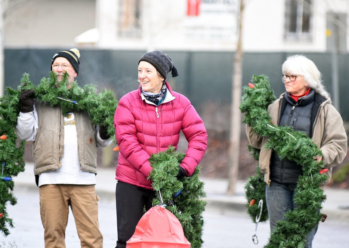 Volunteers descended on downtown Whitefish Sunday morning to hang up the winter decorations.