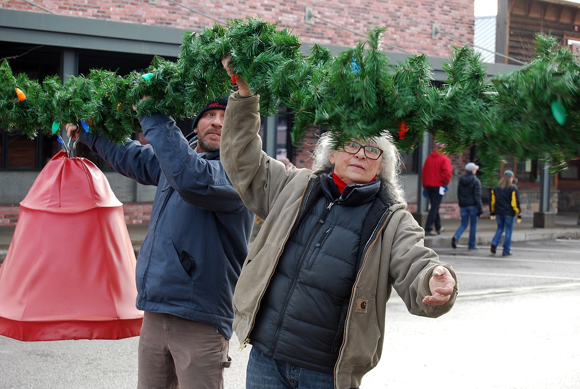 Volunteers descended on downtown Whitefish Sunday morning to hang up the winter decorations.