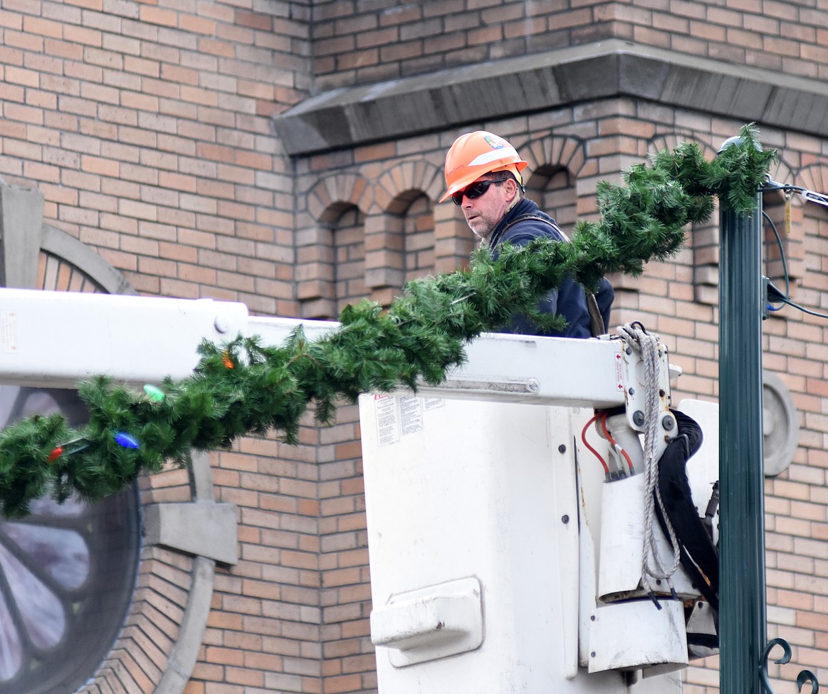 Lineman from Flathead Electric Co-op were part of the volunteer crew Sunday morning that hung the winter decorations in downtown Whitefish.