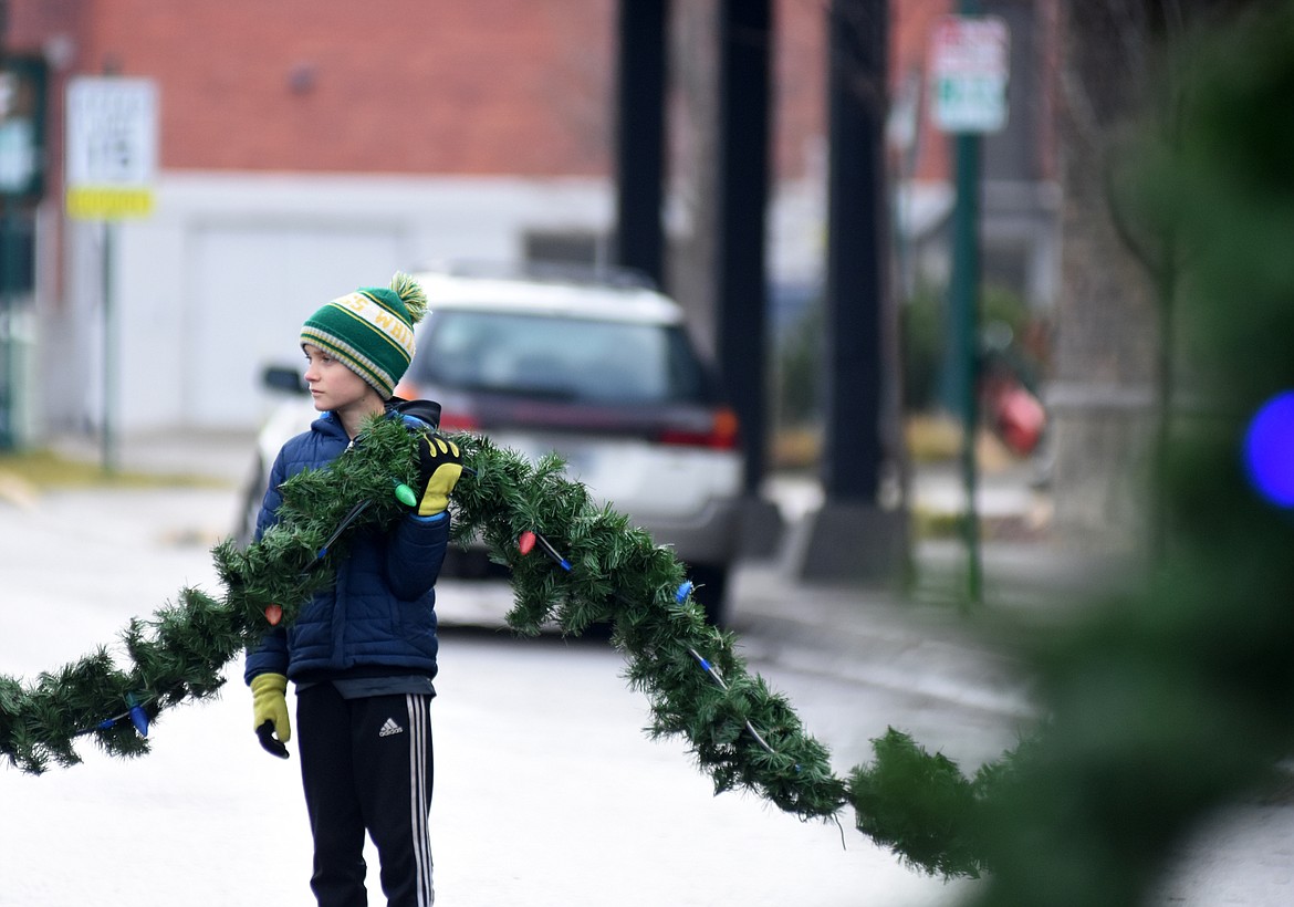 Volunteers descended on downtown Whitefish Sunday morning to hang up the winter decorations.