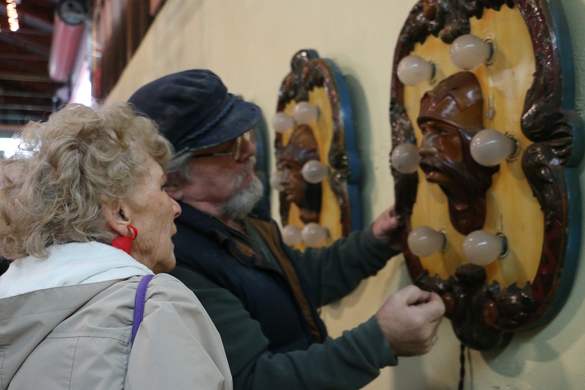 &#151;Photo by MARY MALONE
Dan Mimmack, right, of Sandpoint, checks out the woodwork on the fully intact rounding board shields that are part of a 1920 carousel, which after being packed away for 64 years, was removed from its vintage trailers in the Sandpoint Granary Warehouse Saturday.