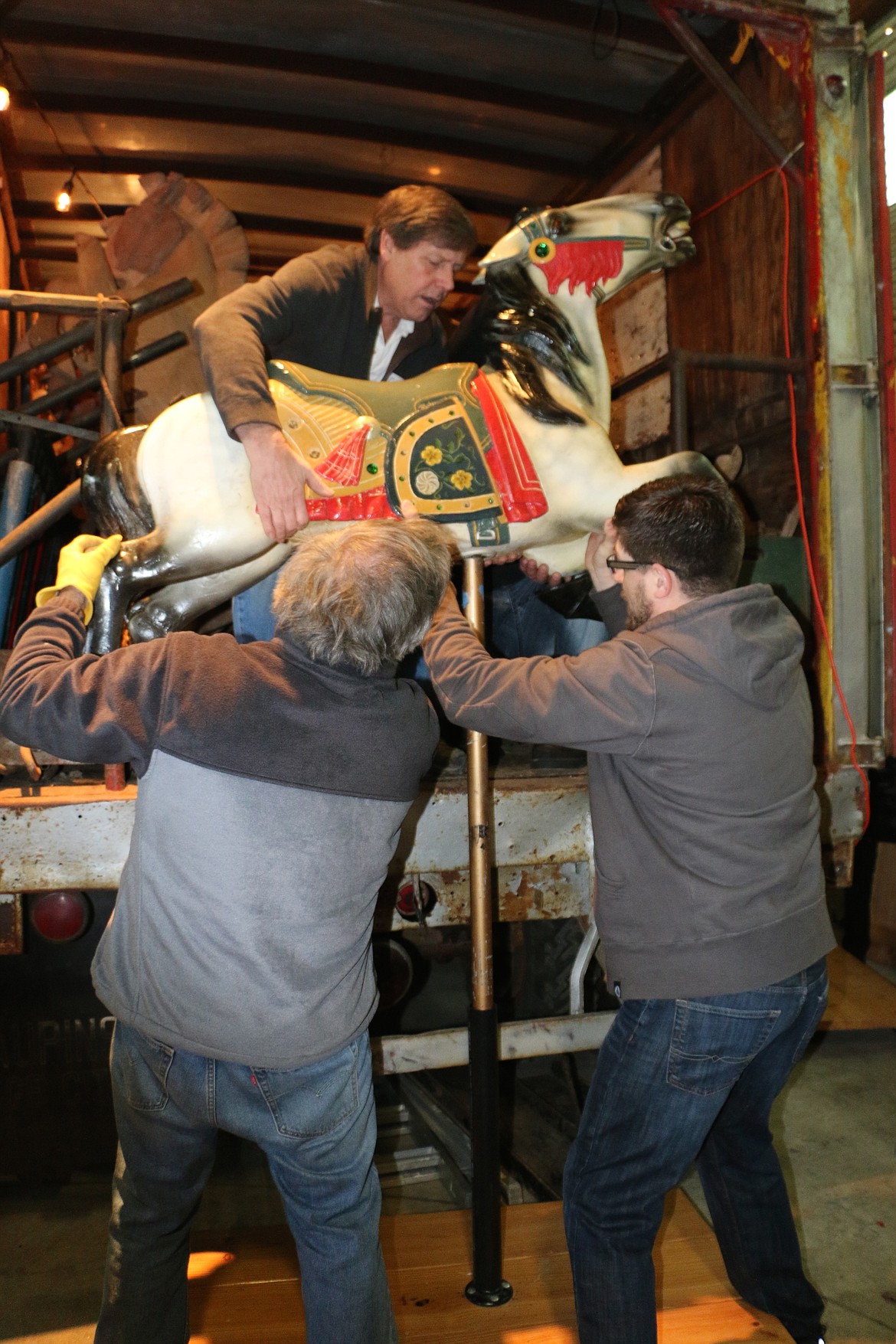 &#151;Photo by MARY MALONE
Clay Hutchison removes one of the two painted carousel horses Saturday at the Sandpoint Granary Warehouse after its 64 years of slumber. The 36 hand-carved wooden horses are part of a 1920 carousel which Hutchison and his wife, Reno, plan to restore and find a home for in Sandpoint.