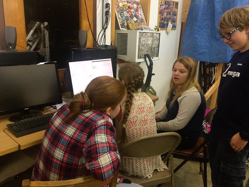 &#151;Photo by ALISA HANNAMAN
From left, Boundary County Middle School Team OMEGA programmers, Grace Hopkins, Morgan Moon, Kaylee McCabe, and OMEGA engineer, Gorge Balk, work on a program for their robot, Tardis, that will be entered in Saturday&#146;s competitions.