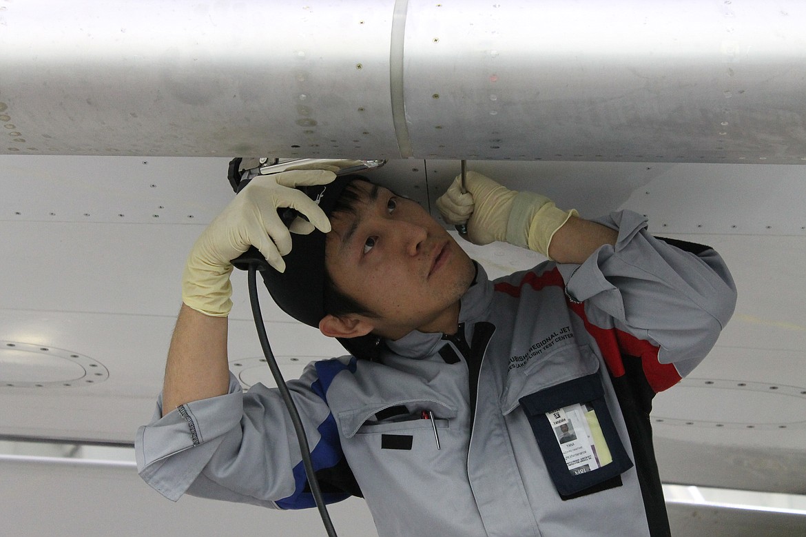 Charles H. Featherstone/Columbia Basin Herald 
Flight Maintenance Specialist Kazuhiro Yanatake applies sealant to a bolt inside the slats of a Mitsubishi Regional Jet (MRJ) at the company&#146;s Moses Lake testing facility on Sunday.