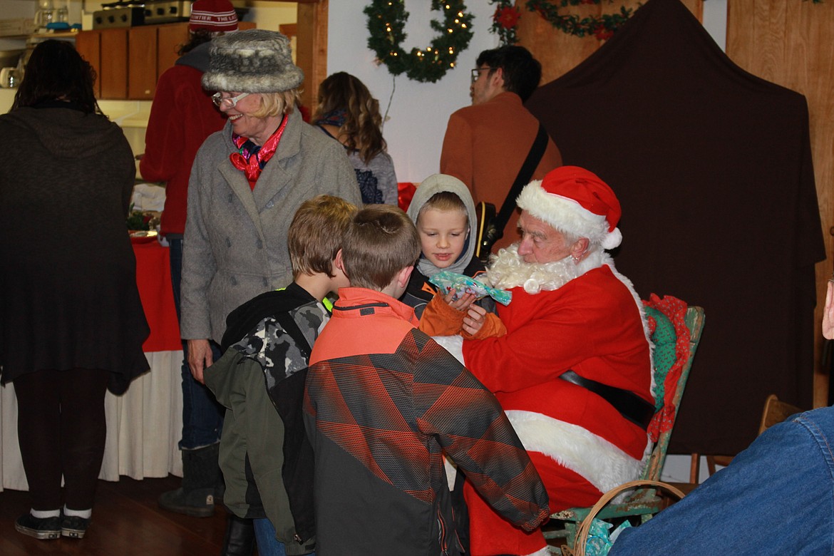 Kids crowded around Santa, eager to tell him what they wanted for Christmas at the annual Schoolhouse Lighting event in DeBorgia.