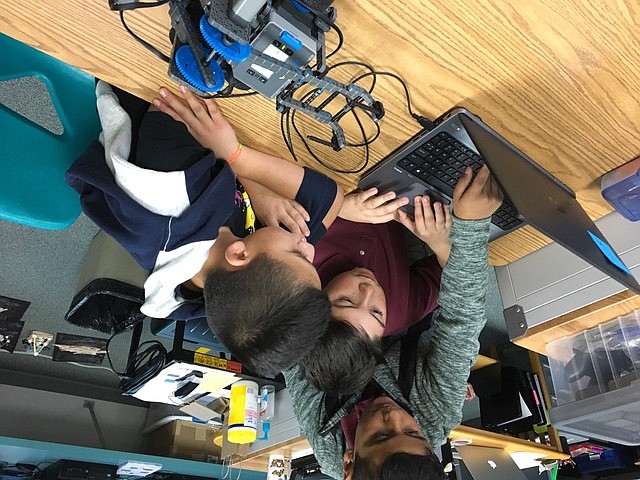 Cesar Ortiz/Courtesy photo - From left, Brian Herrera, Carlo Ramirez and Julian Paramo program their robot.