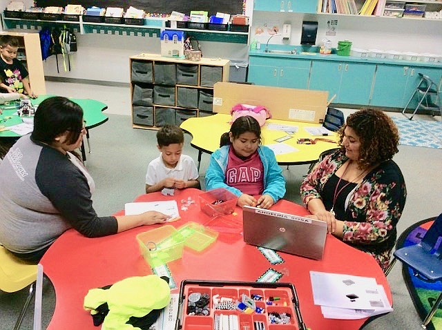 Cesar Ortiz/Courtesy photo - With assistance from Katie Ruiz, left, and Angelina Sosa, Victoro Pareja and Shailah Herrera construct their competition robot.