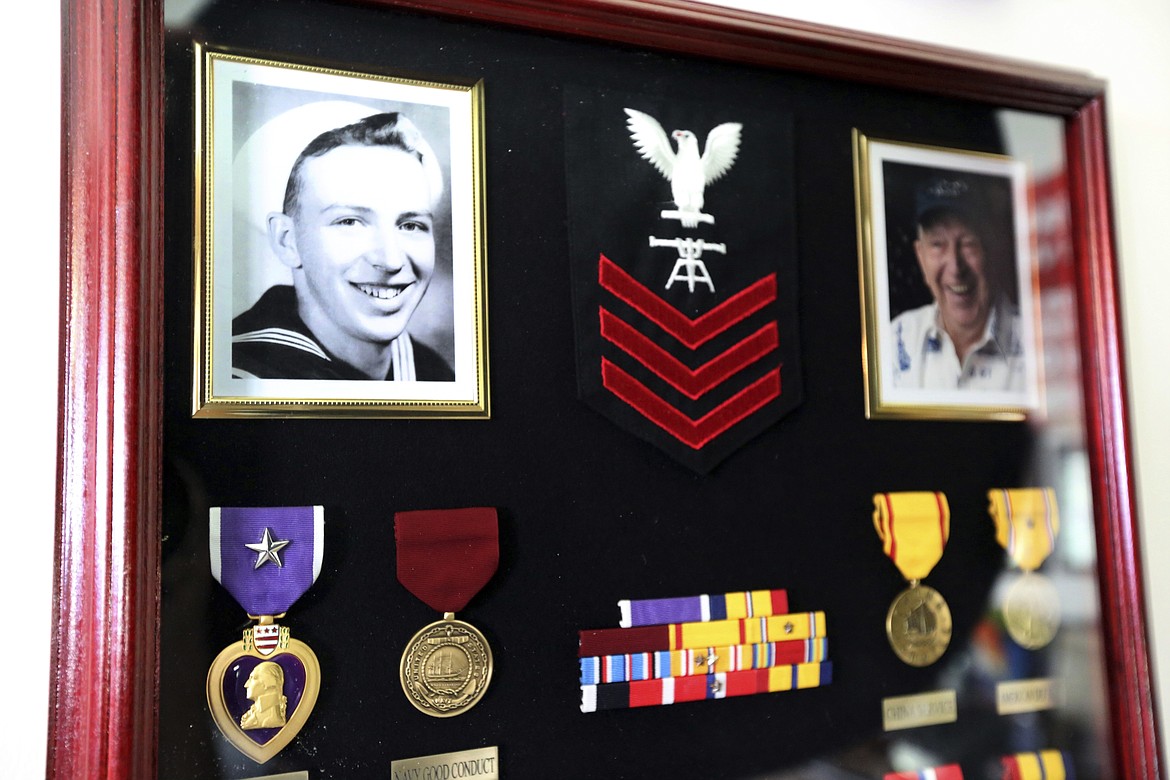 This Thursday, Nov. 17, 2016 photo shows a framed photo of Lauren Bruner, one of five remaining survivors of the USS Arizona from the Dec. 7, 1941 Japanese attack on Pearl Harbor, and his medals, from lower left, the Purple Heart, Navy Good Conduct medal and other awards, at his home in La Mirada, Calif. Burns covered most of Bruner's body after Japanese planes bombed the sailor's battleship in Pearl Harbor. He spent seven months recovering in the hospital, and returned to fight in more battles. (AP Photo/Reed Saxon)