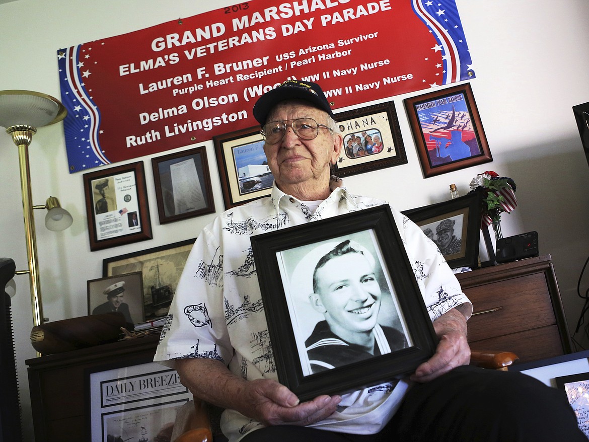 LEFT: In this Thursday, Nov. 17, 2016 photo, Lauren Bruner, one of five remaining survivors of the USS Arizona which was attacked on Dec. 7, 1941, holds with a 1940 photo of himself, at his home in La Mirada, California. Bruner was getting ready for church when the alarm on his battleship sounded. (AP Photo/Reed Saxon)