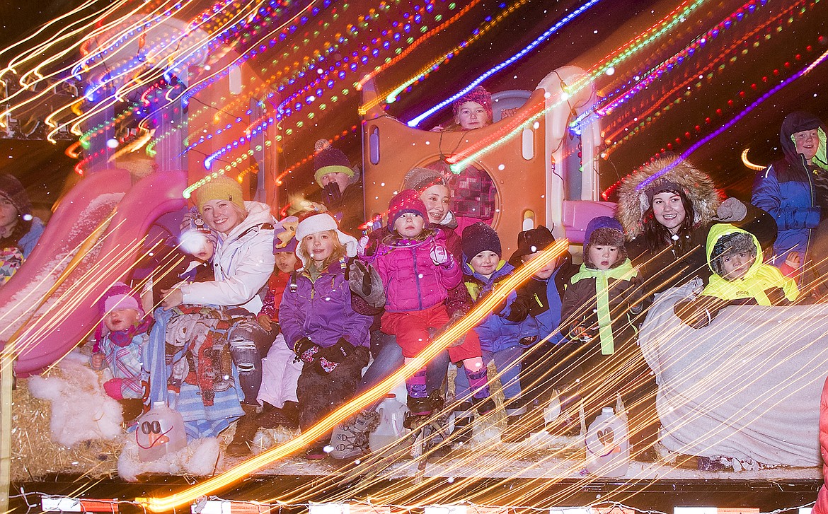 Children wave from a brightly-colored float as it goes down Nucleus.