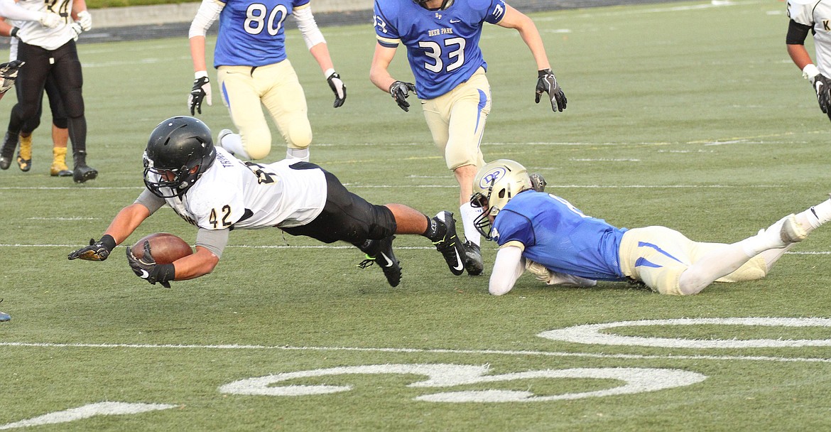 Pete Christensen Photo - Adrian Trinidad lunges for the 30-yard line after a seven-yard run.