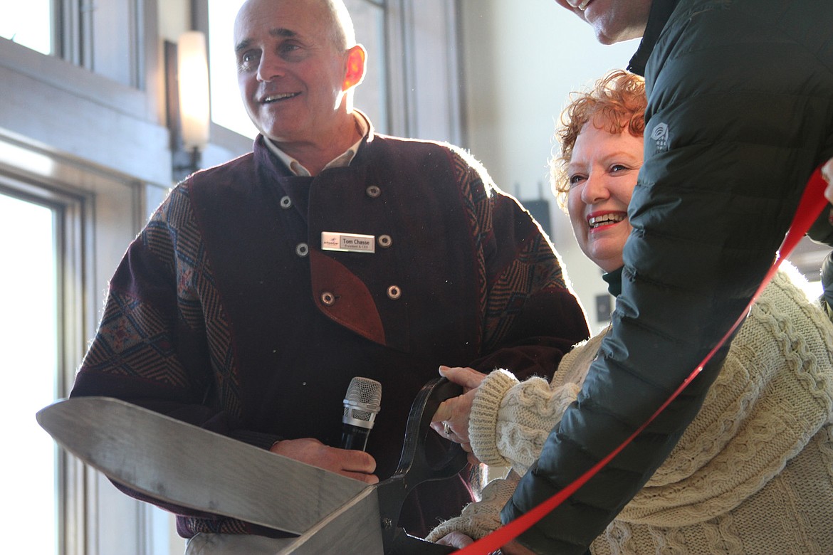 &#151;Photo by KEITH KINNAIRD
Schweitzer CEO Tom Chasse, left, and Kate McAlister of the Greater Sandpoint Chamber of Commerce cut the ribbon the Sky House lodge on the Schweitzer summit on Friday. Matt Borud of Idaho Commerce is partially obscured.