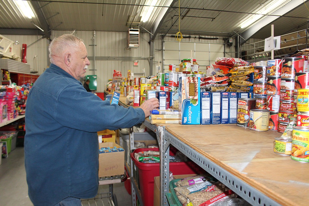 Cheryl Schweizer/Columbia Basin Herald
Gary Simpson organizes the last few cans and boxes for the Othello Christmas Basket project.