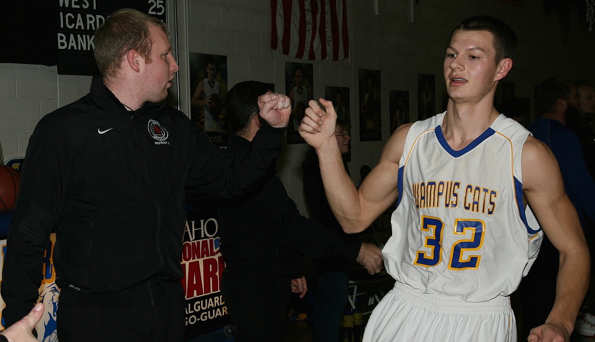 &#151;Photo by ERIC PLUMMER
Former Wampus Cat hoopster Mike Martin, now a seasoned basketball and football official in the North Idaho Association, gives a fist bump to current Wampus Cat Hunter Boudousquie before a league game recently. It seems like just yesterday that Martin, who excelled at football, basketball and tennis as a student at Clark Fork, was lighting up North Star League scoreboards. Martin, who was the North Star League Most Valuable Player as a quarterback a decade ago, was honored recently as Sophomore of the Year by the North Idaho Football Officials Association, which covers the five northern counties of Idaho. Martin is one of a handful of current high school sports officials with Clark Fork ties.