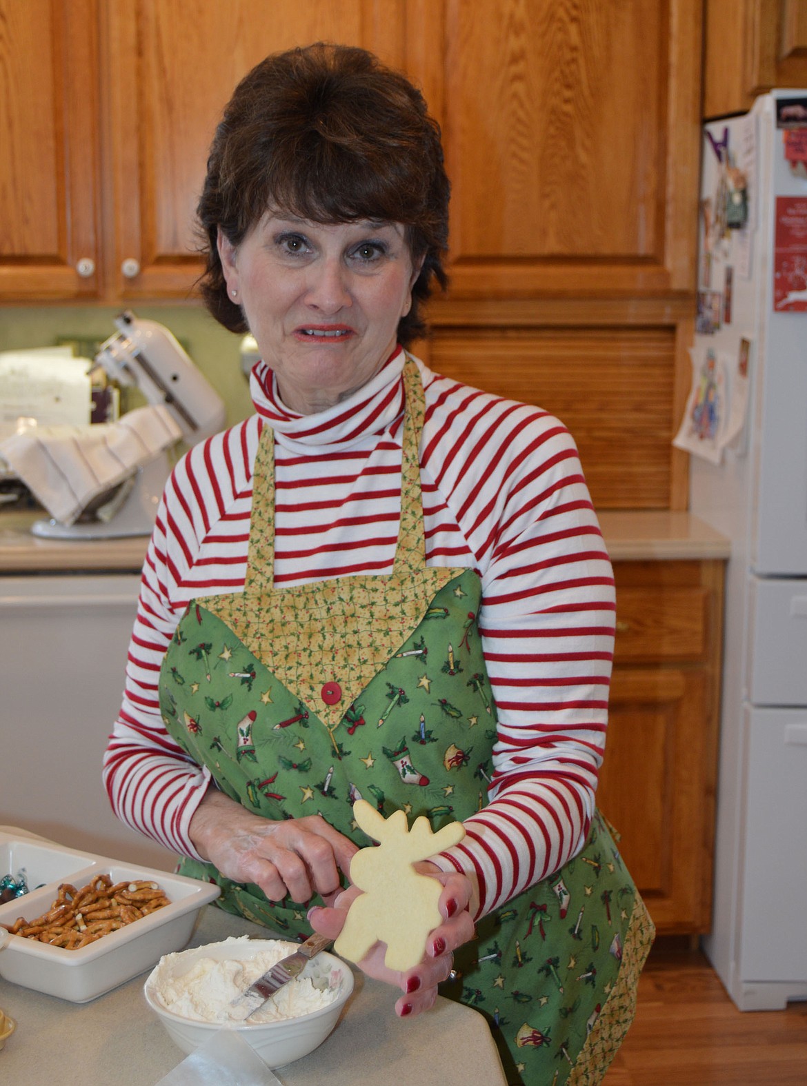 Donna Danz shows off a moose-shaped sugar cookie, one of many shapes she baked to send to family for Christmas. (Anna Arvidson photo)