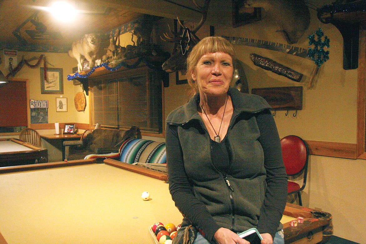 Carry Mick, owner of Happy&#146;s Inn, sitting on the 100-year-old pool table in Happy&#146;s Inn. (Bethany Rolfson/TWN)