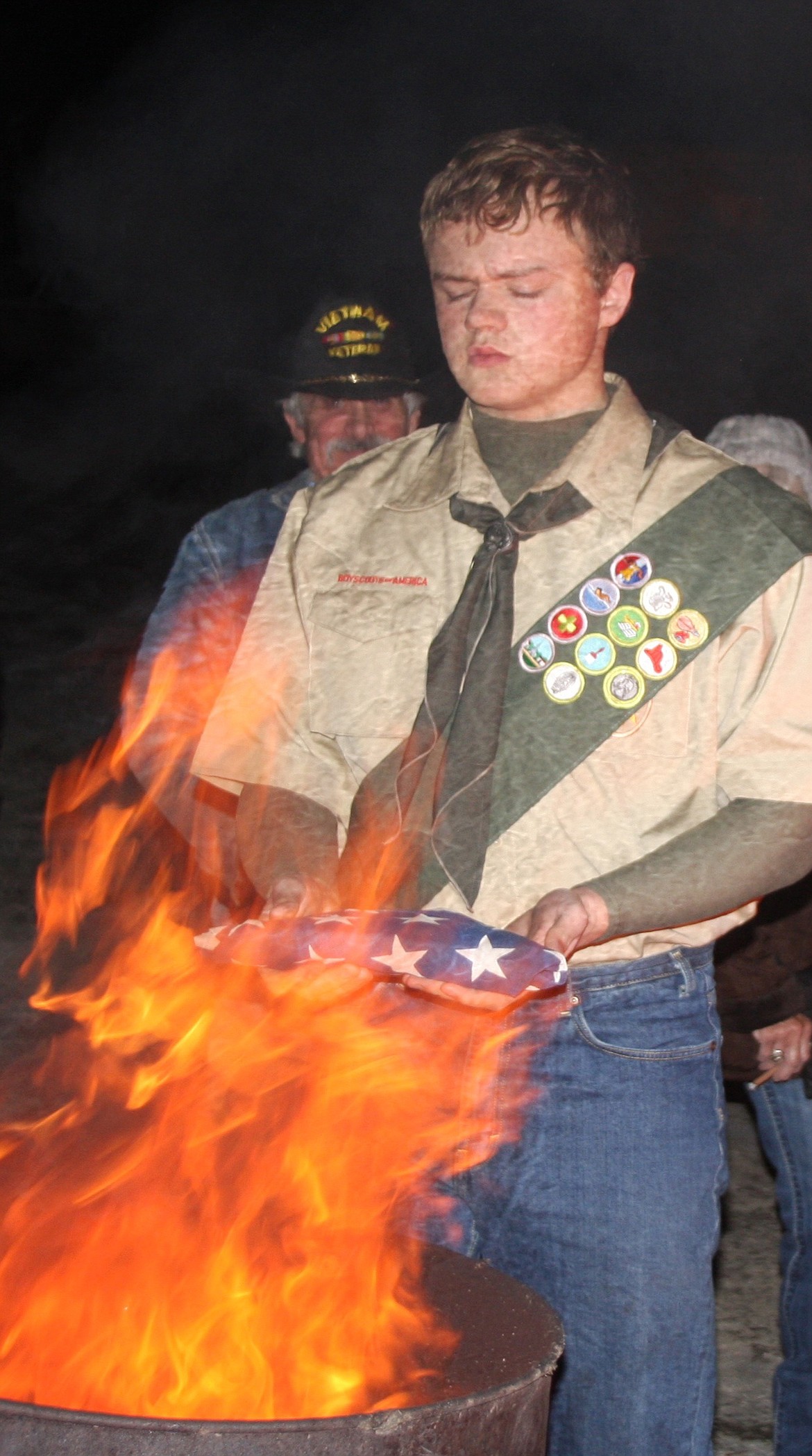 NOAH HATHORNE, JR. readies a retired flag for the fire. (Lisa Larson/Clark Fork Valley Press)