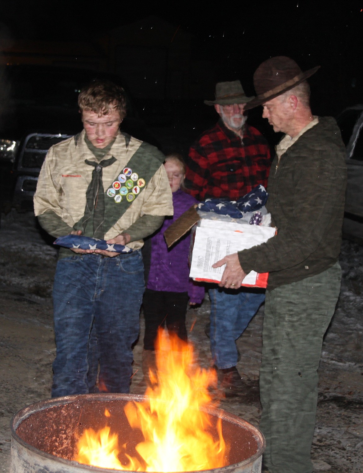 STAR SCOUT Noah Hathorne, Jr., presents a flag along with his father, Scoutmaster Noah Hathorne. (Lisa Larson/Clark Fork Valley Press)