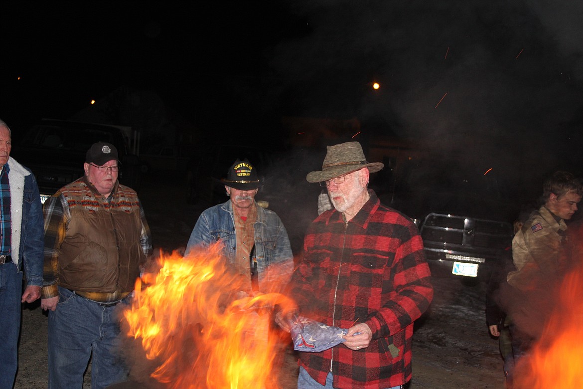 DON LYNCH brings a retired flag toward the fire. (Clark Fork Valley Press photos)