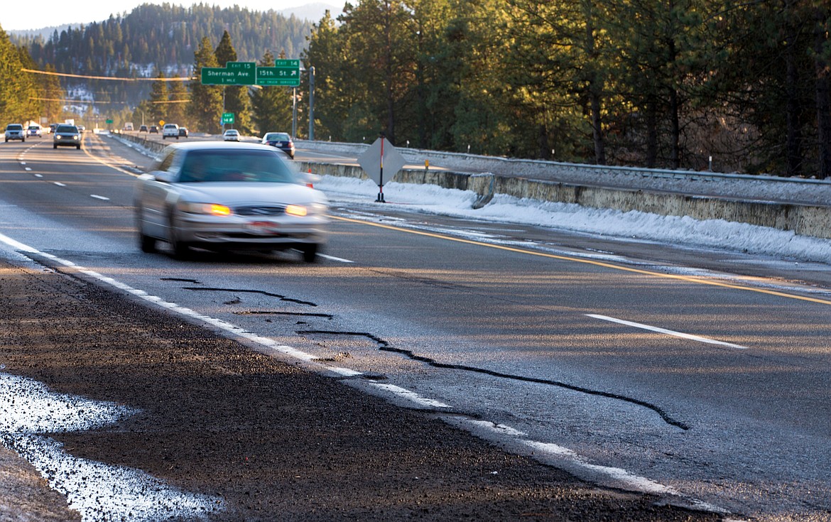 JAKE PARRISH/Press
A car drives past potholes in the westbound lanes on Interstate 90 Wednesday near the Fourth Street off-ramp. The Idaho Transportation Department said it will be repairing the potholes in coming weeks.