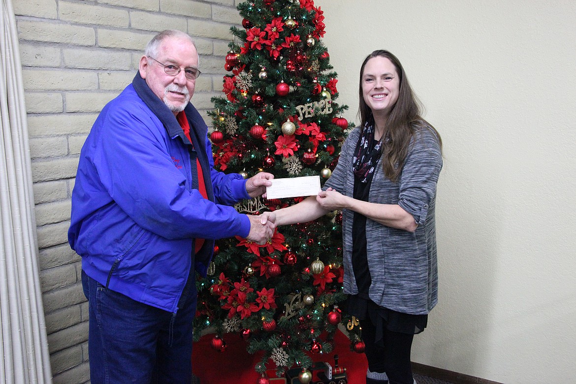 Chanet Stevenson/The Sun Tribune 
Jamie Krueger of Caring Neighbors presents Roy Dodge of the Othello Senior Center Thursday with a $1,000 grant toward the center&#146;s beautification project.