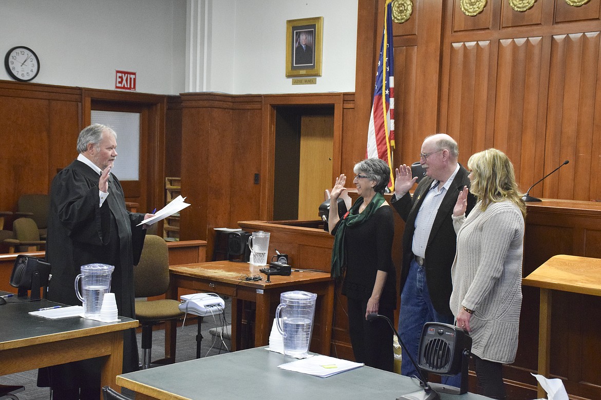 LAKE COUNTY District Court Judge James A. Manley, left, swears in Superintendent of School Carolyn Hall, County Commissioner Dave Stipe and Clerk of District –Court Lyn Fricker on Dec. 21. (Brett Berntsen/Lake County Leader)