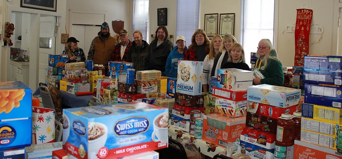 Helping Hands volunteers in Alberton put together holiday baskets for 11 families in need which included food, gifts, and a family night package. (Kathleen Woodford/Mineral Independent)