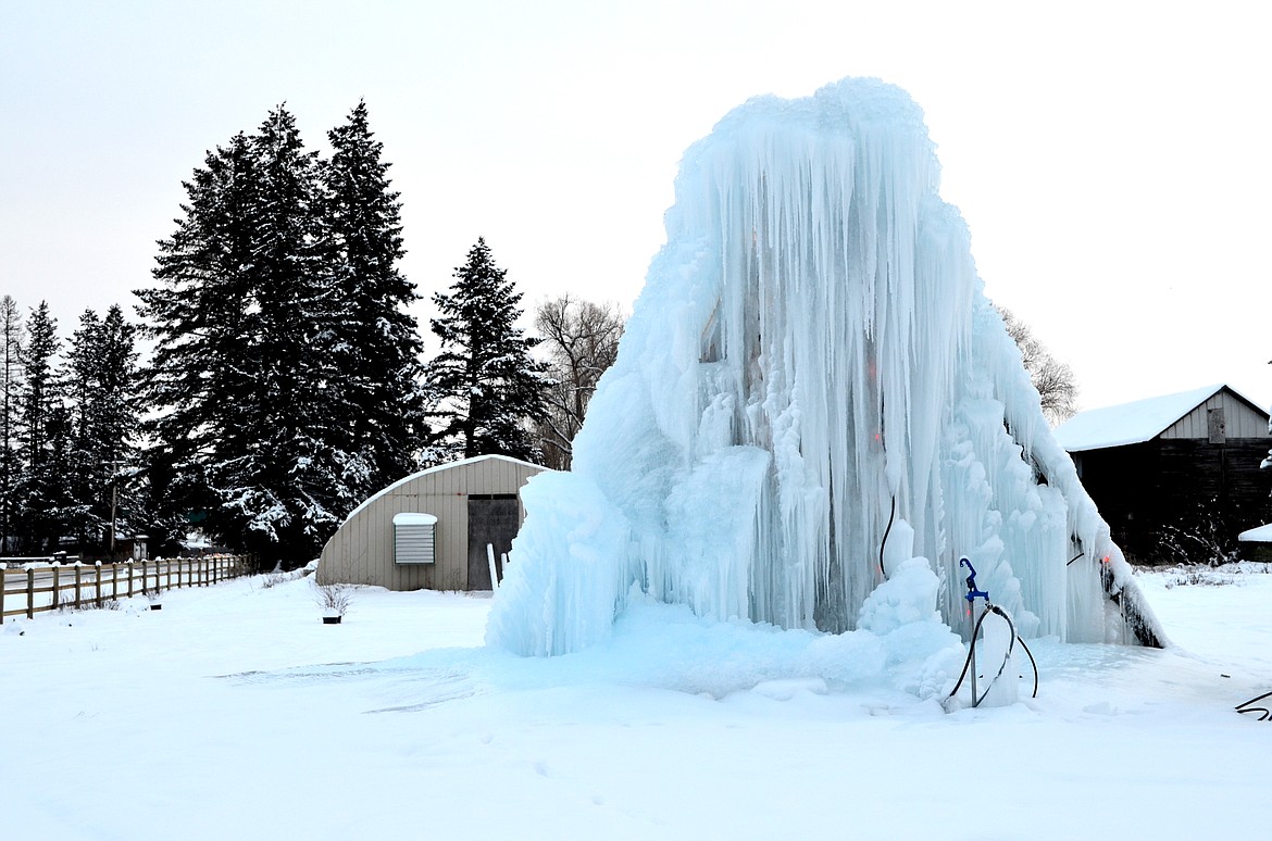The Olsen family constructed their ice castle  near Helena Flats Road with a pickup standing on its nose, propped up with a wooden beam. The figure stands about 20 feet tall. (Seaborn Larson/Daily Inter Lake)