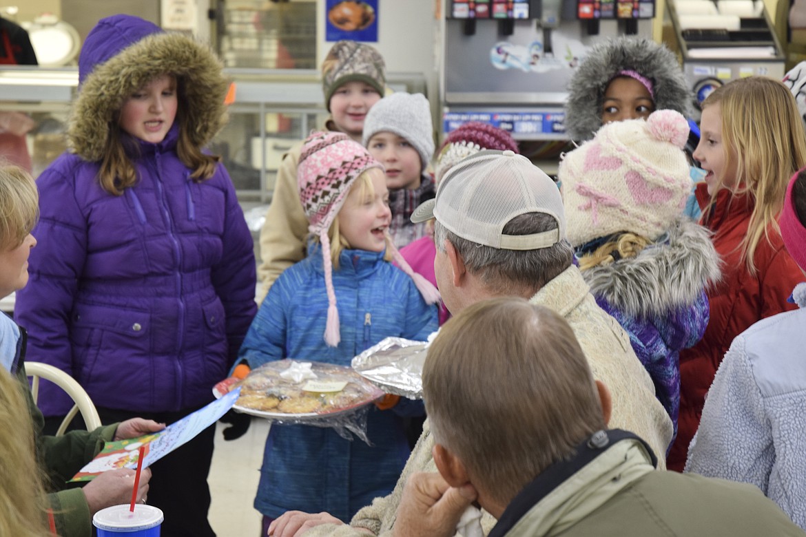 HAVEN HOULE, left, and Bailee Woll present cookies to customers of Pablo Family Foods on Friday.