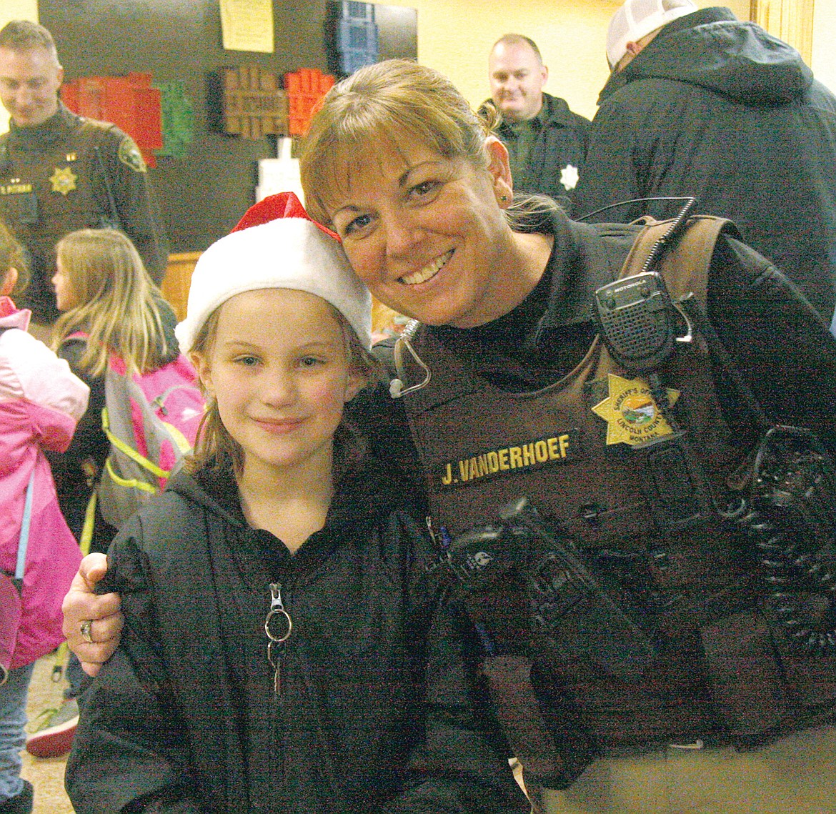 Sheriff&#146;s Deputy Jessica Vanderhoef and Chloe Reid, who was sporting a Santa hat before venturing out for the fourth annual Shop for a Cop. (Bethany Rolfson/TWN)