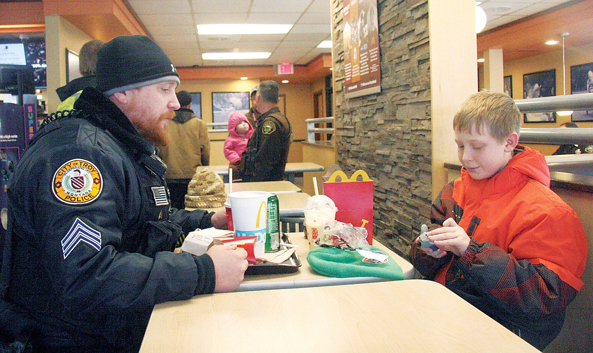 Troy Police Officer Chris Pape and Dustin Bowers inspecting Bower&#146;s new Happy Meal&reg; (Bethany Rolfson/TWN)
