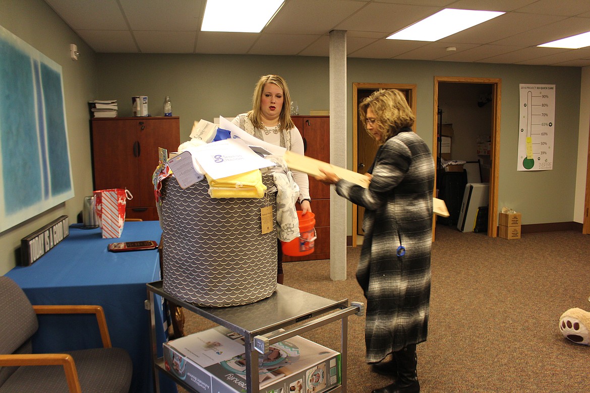 Cheryl Schweizer/Columbia Basin Herald
Gretchen Youngers (left) and Kim Pope (right) of Samaritan Healthcare&#146;s community relations department load a cart with gifts for the hospital&#146;s New Year baby.