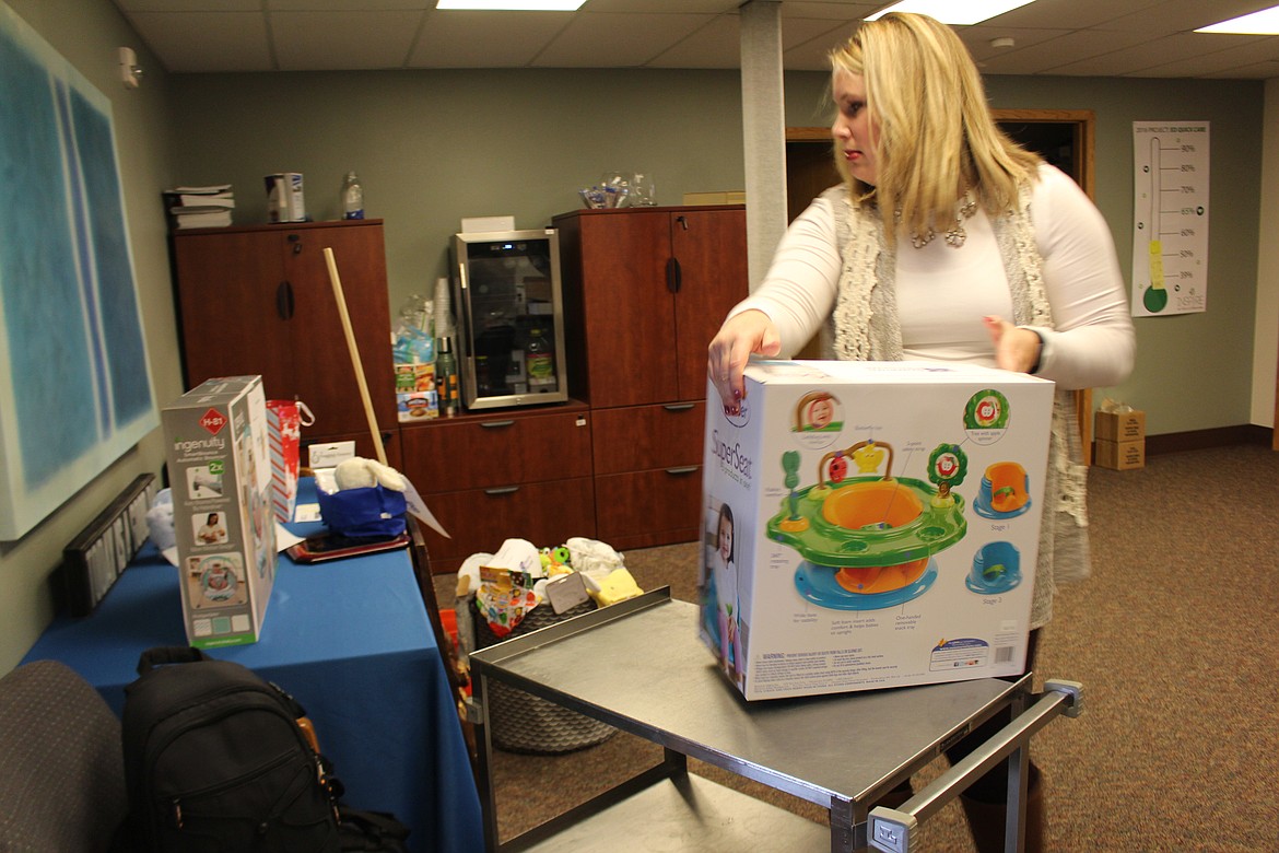 Cheryl Schweizer/Columbia Basin Herald
Gretchen Youngren, communications director at Samaritan Hospital, loads a cart with gifts for the New Year baby.