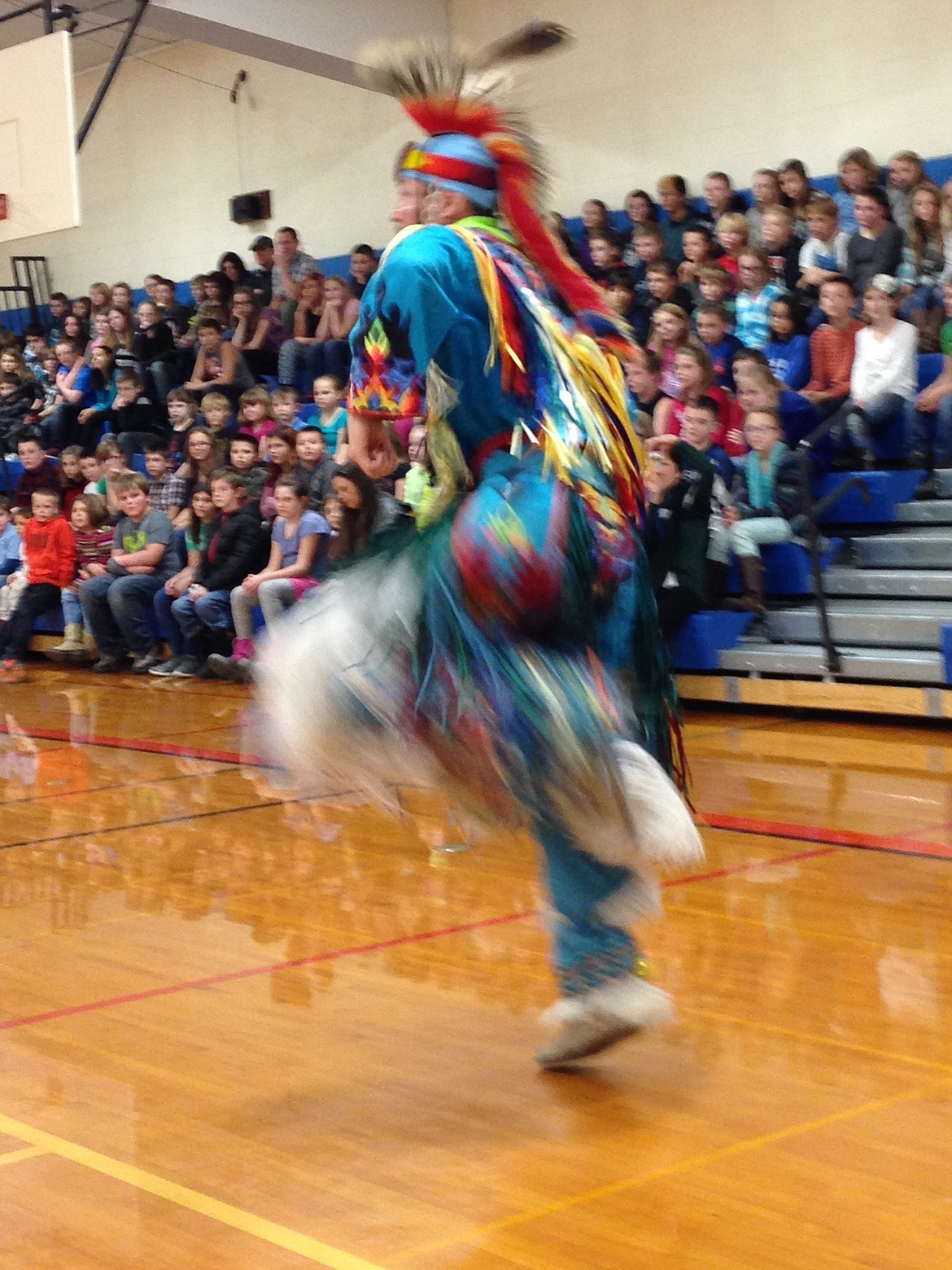 (Photo courtesy IDAHO MYTHWEAVER)
Kalispel tribal member Raymond Finley demonstrates to Priest River Elementary students the techniques of grass dancing in December 2015 visit to the school.