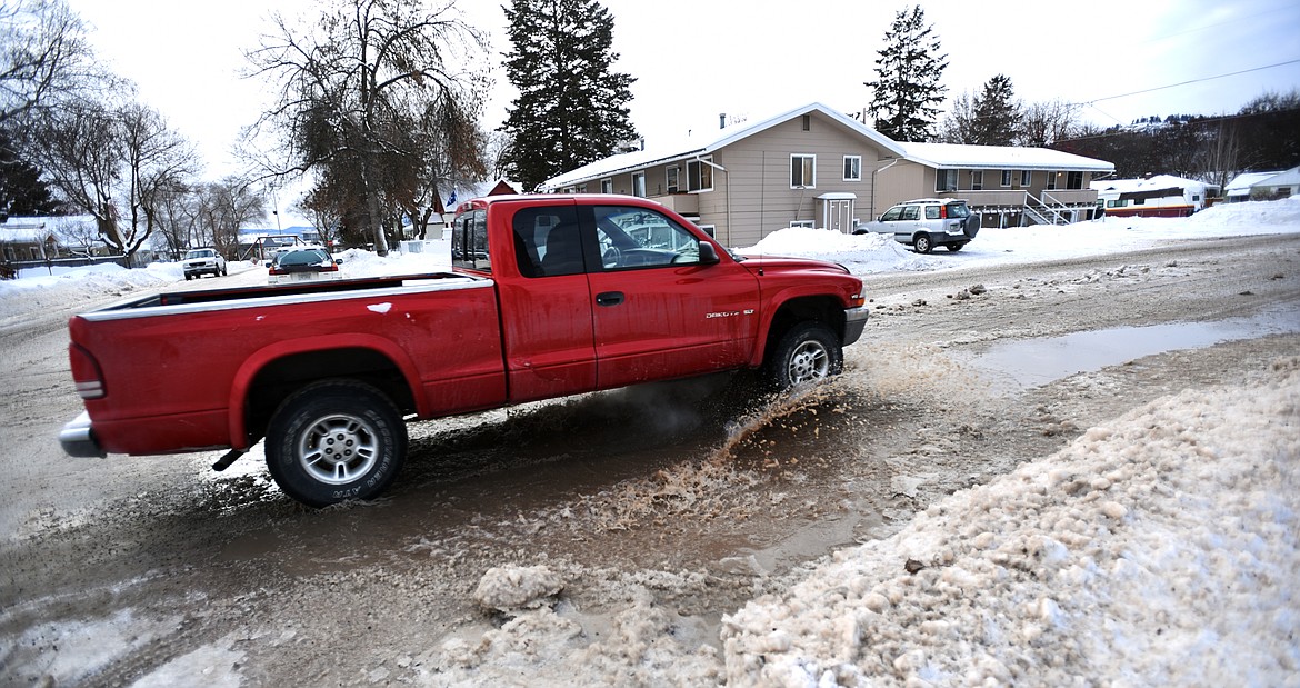A truck drives through run off from a water main break in Kalispell on 11th Street West on Tuesday morning, January 3.(Brenda Ahearn/Daily Inter Lake)