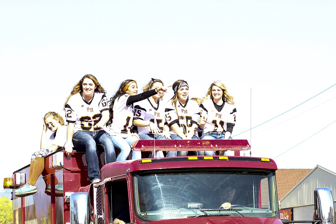 Members of the Plains volleyball team cruise on top of a fire engine during the Homecoming parade on Sept. 30.