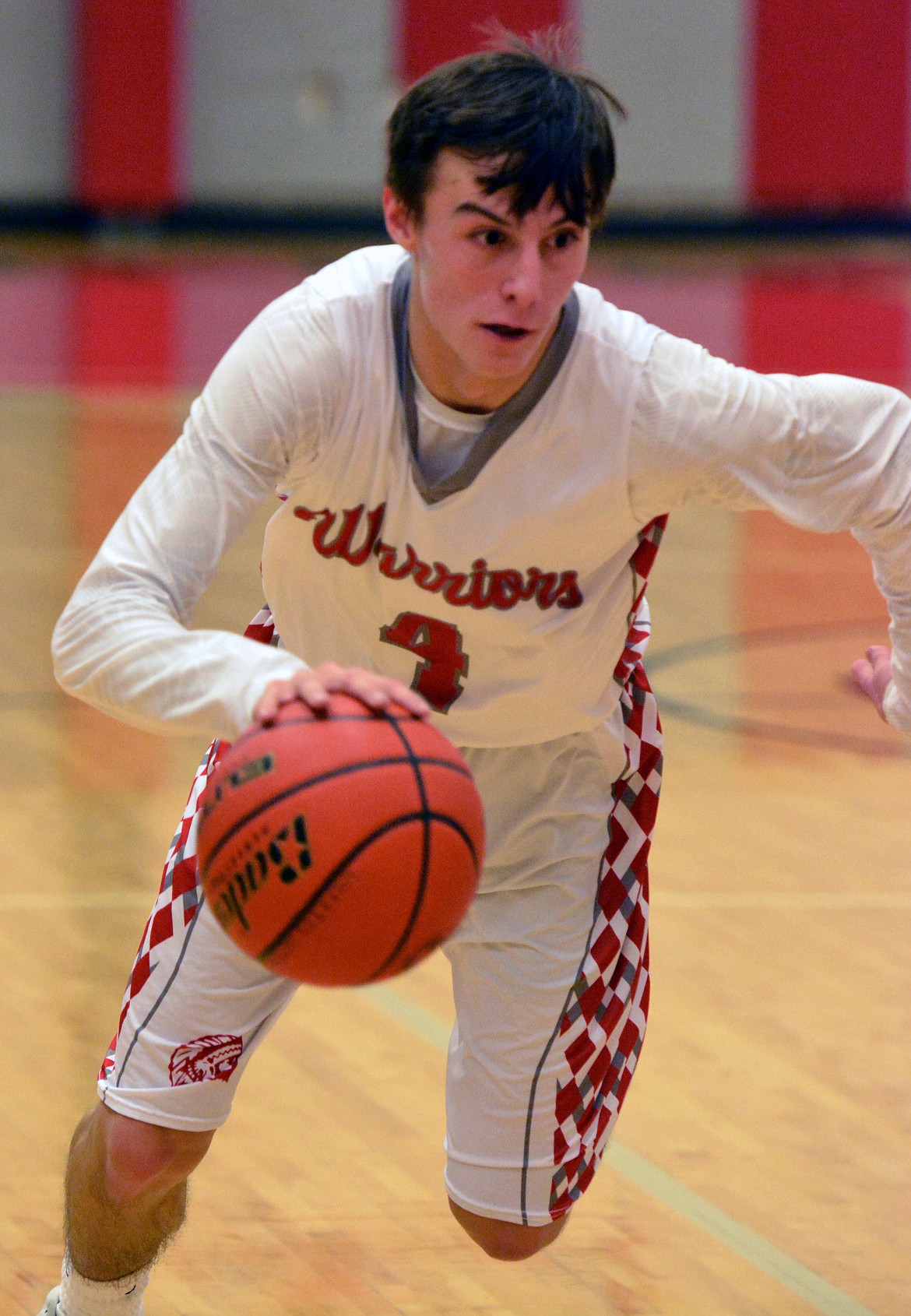 ARLEE HIGH School guard Phillip Malatare drives the lane in a recent game against St. Regis. The Warriors look to build on its momentum headed into the second half of the season. (Jason Blasco/Lake County Leader)