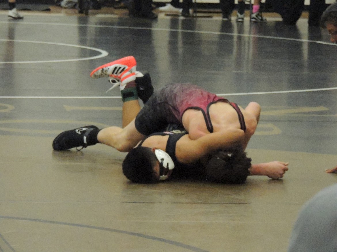 Ted Escobar/The Sun Tribune - Eduardo Rodriguez, black, appears to be in trouble in a first-round 126-pound match, but he&#146;s in control, using the opponent&#146;s head to bring him over for a pin.