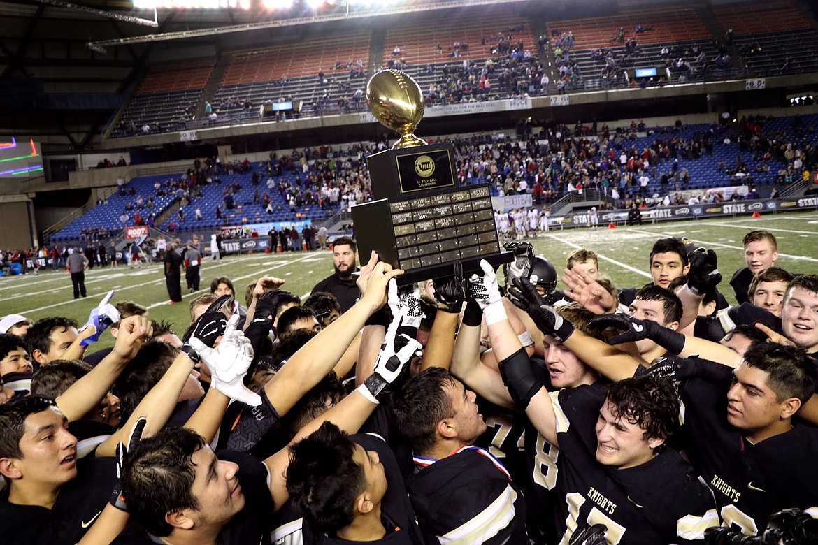 Pete Christensen - The Royal High School football team celebrates after receiving the school&#146;s seventh state 1A championship trophy Saturday at the Tacoma Dome. The Knights defeated Connell, 25-10, to complete a 13-0 season.