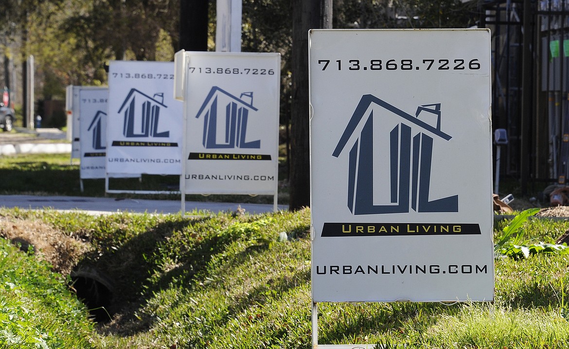 FILE - In this Tuesday, Feb. 16, 2016, file photo, &quot;For Sale&quot; signs are stacked up outside a new complex of townhouses in Houston. On Thursday, Dec. 1, 2016, Freddie Mac reports on the week's average U.S. mortgage rates. (AP Photo/Pat Sullivan, File)