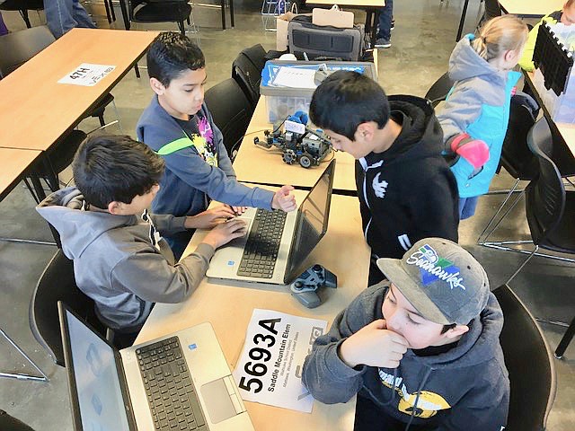 Ted Escobar/The Sun Tribune - Left to right, Allessandro Maravilla, Sergio Leon, Brian Herrera and Carlo Ramirez program their robots.