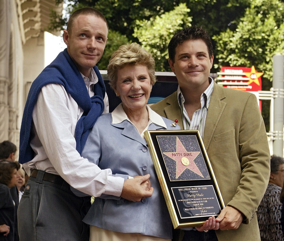 In this Aug. 17, 2004 file photo, Academy Award winner, and television actress Patty Duke poses with her sons, actors Mackenzie Astin, left, and  Sean Astin after being honored with a star on the Hollywood Walk of Fame in Los Angeles. Duke, who won an Oscar as a child at the start of an acting career that continued through her adulthood, died Tuesday, March 29, 2016, of sepsis from a ruptured intestine. She was 69. (AP Photo/Damian Dovarganes, File)