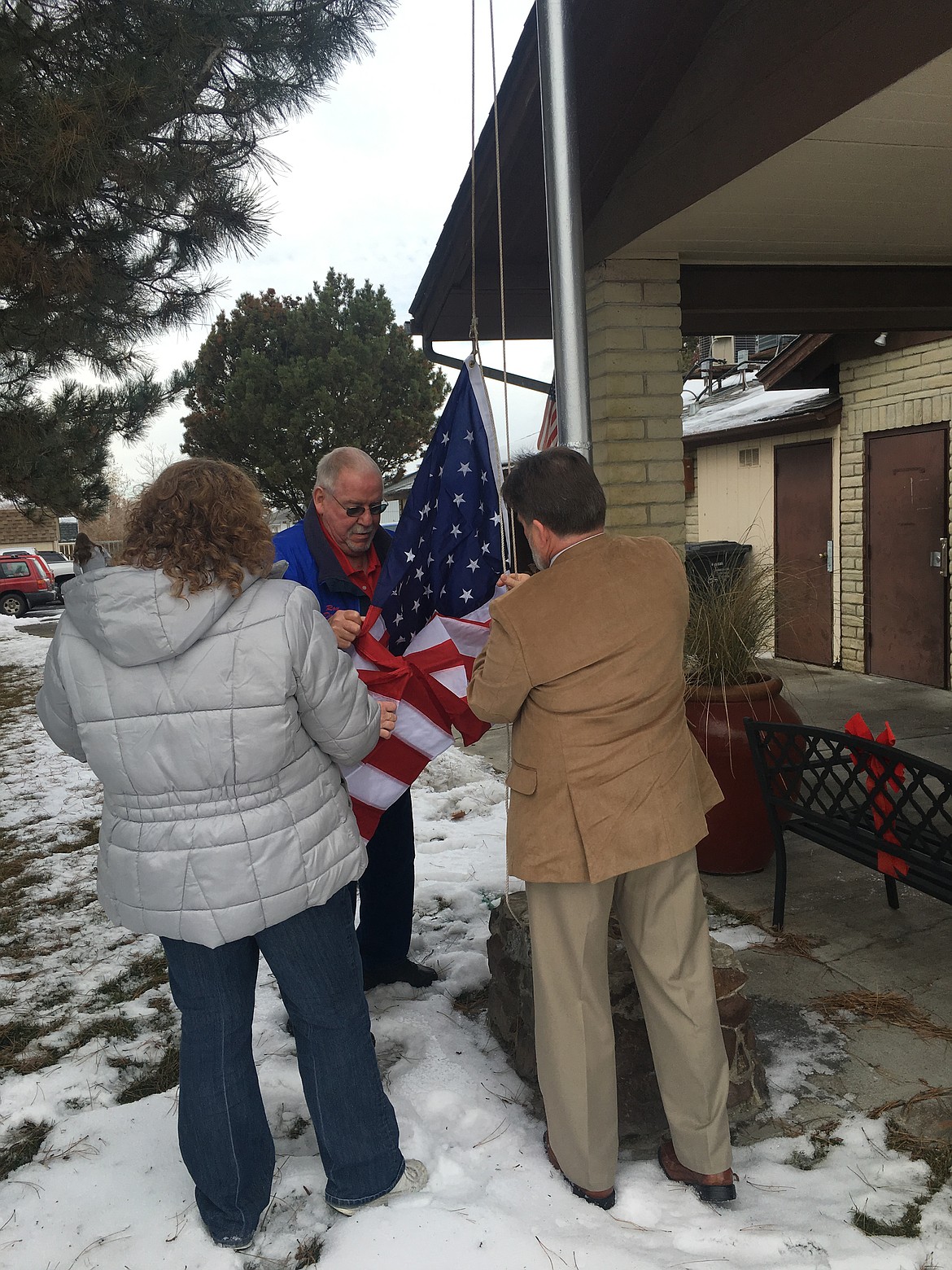 Chanet Stevenson/The Sun Tribune - Roy Dodge, president of the Othello Senior Center, helps raise the flags on the newly refurbished flag pole Thursday. The new U.S. and Washington State flags were from the state Capitol, and were presented to Dodge by Senate Majority Leader Mark Schoesler.