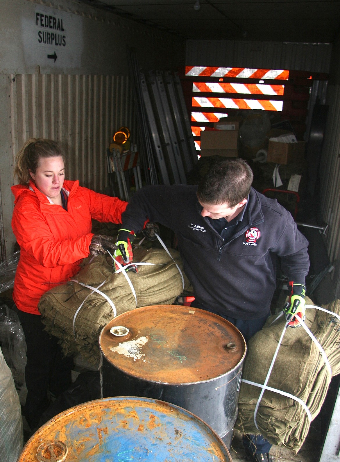 BRIAN WALKER/Press
Ashley Frederick, preparedness coordinator for the Kootenai County Office of Emergency Management, hands off sand bags to Northern Lakes Firefighter Ryan Alltus inside Kootenai County's rail car container storage near the Coeur d'Alene Airport on Wednesday.