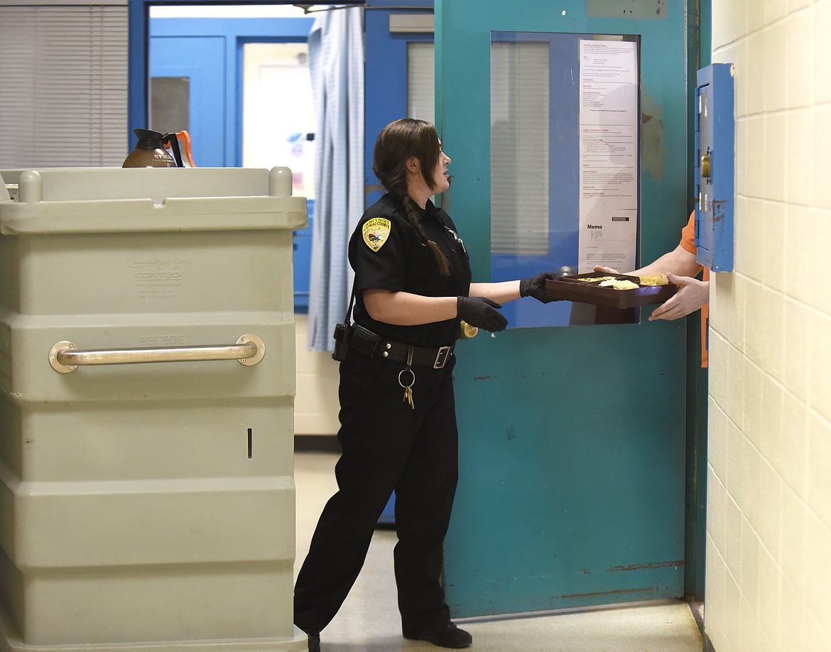 Flathead County Sheriff&#146;s detention officer Schaible passes out lunch at the Flathead County Jail on Thursday. (Aaric Bryan/Daily Inter Lake)