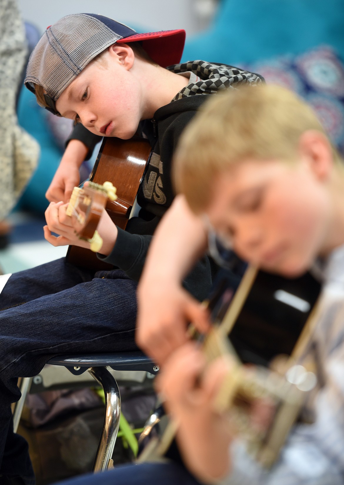 Cooper Cosand, 9, and Sam Plummer, 10, both of Bigfork, practice playing chords in the Bigfork ACES Beginning Guitar Class at Bigfork Middle School.