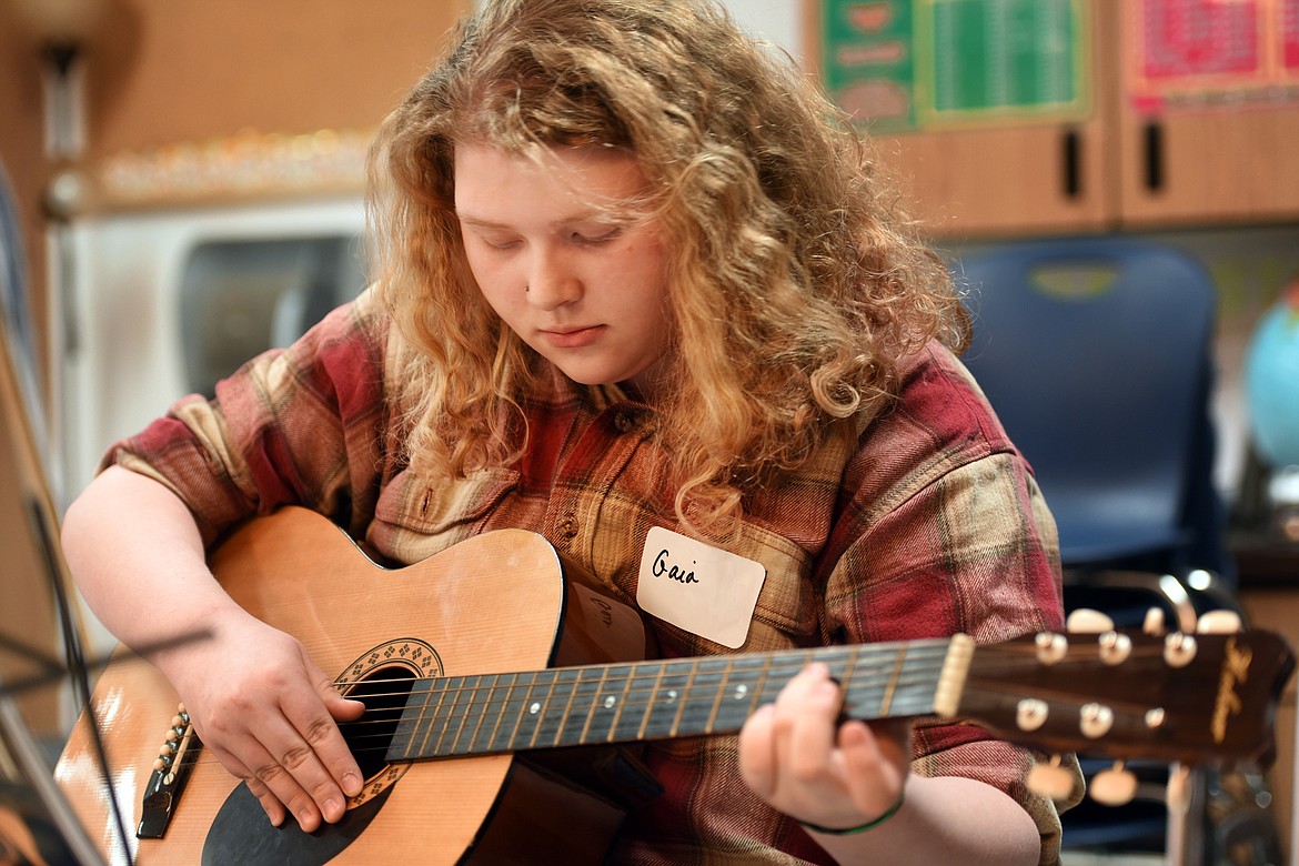 Gaia Azure, 14, of Bigfork, practices playing chords on Monday, Jan. 9.
