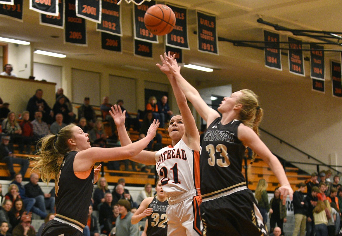 Flathead guard Kelsey Gillespie scores a basket over Helena Capital defenders Aubrey McMaster (4) and Aryn Cummings (33) during the first quarter at Flathead on Friday. (Aaric Bryan/Daily Inter Lake)