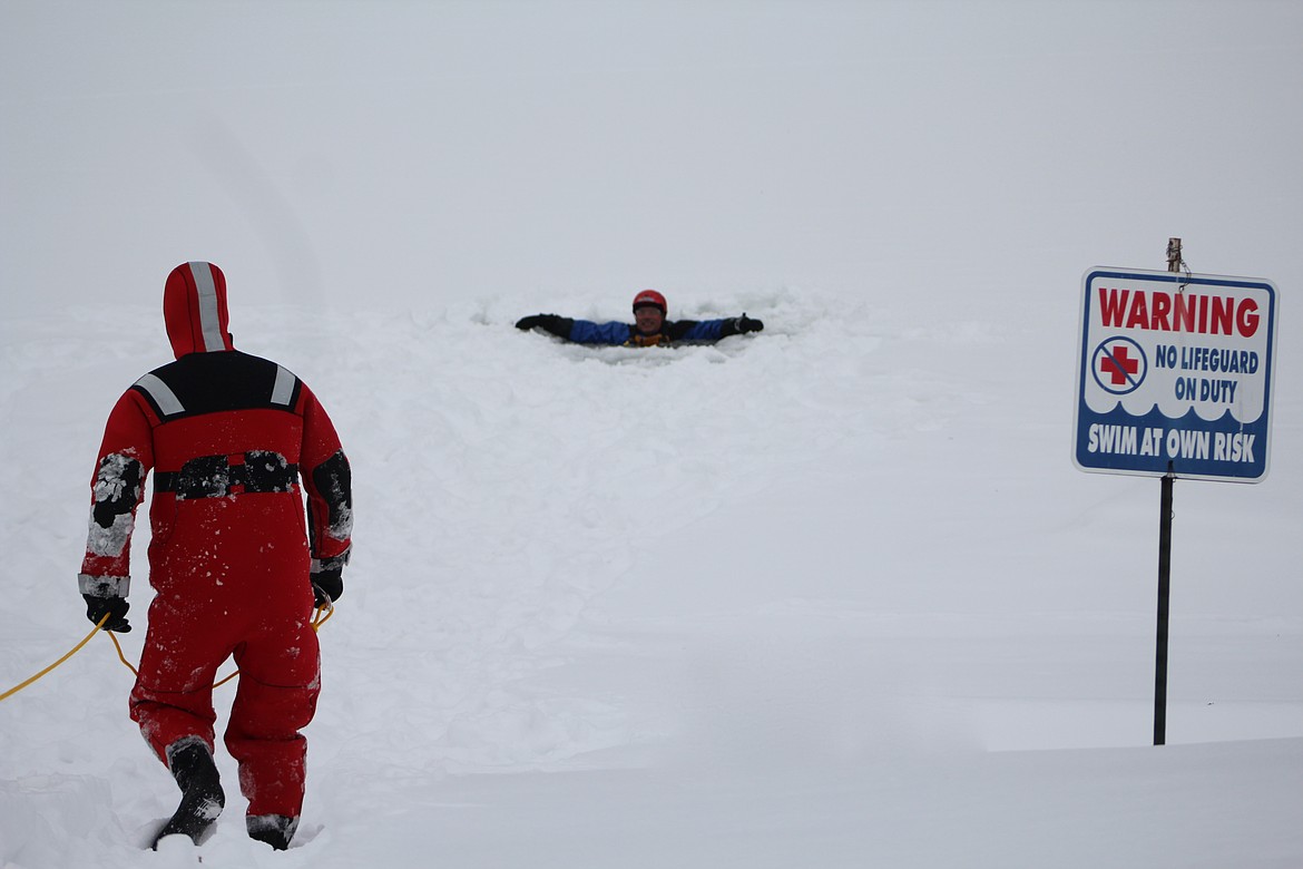 Photo by STAR SILVA
Burlington Northern Santa Fe contractor and Kennedy-Jenks Senior Project Manager Ron Burke is emerged in an ice hole on the Kootenai River Saturday awaiting an ice rescue by Paul Hester of BNSF.