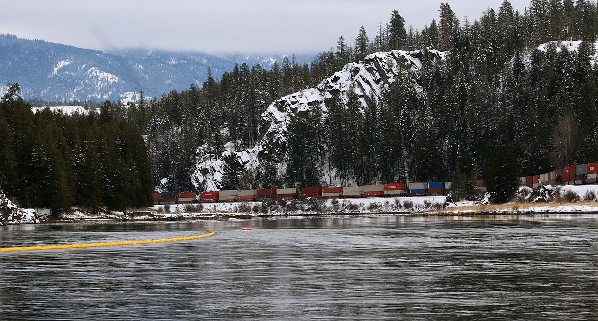 Photo by STAR SILVA
A Burlington Northern Santa Fe train winds around the bank of the Kootenai River Saturday after first responders deploy a yellow line of BNSF boom equipment. The boom is designed to contain any floating contaminants in the rare event of a hazmat release, such as an oil spill. Once contained, the boom would then guide any contaminants into a specialized collection apparatus.